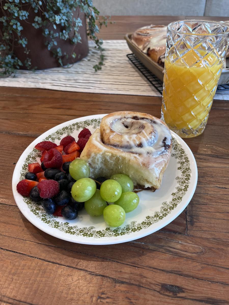 Cinnamon roll with fresh fruit and orange juice